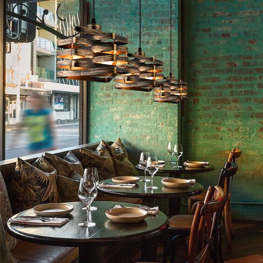 Dining area with round tables, chairs, and decorative lighting fixture in a restaurant.