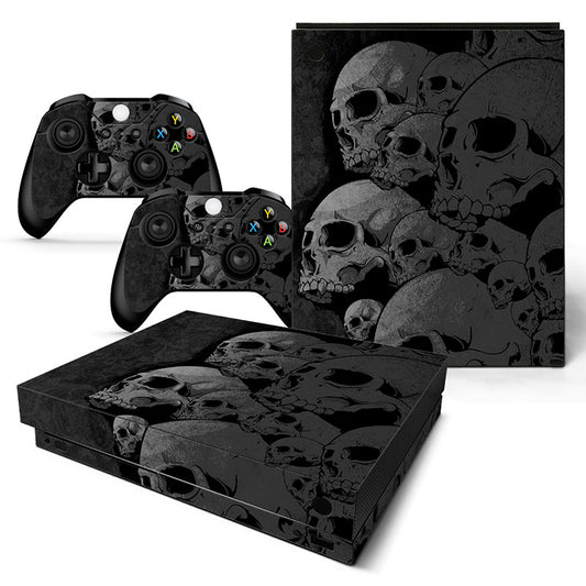 Gaming console and controllers with skull-themed skin on a white background