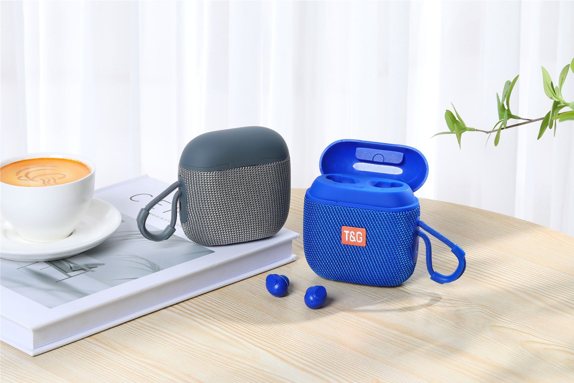 Blue T&G wireless earbuds case on a wooden table with a cup of coffee and a plant in the background.