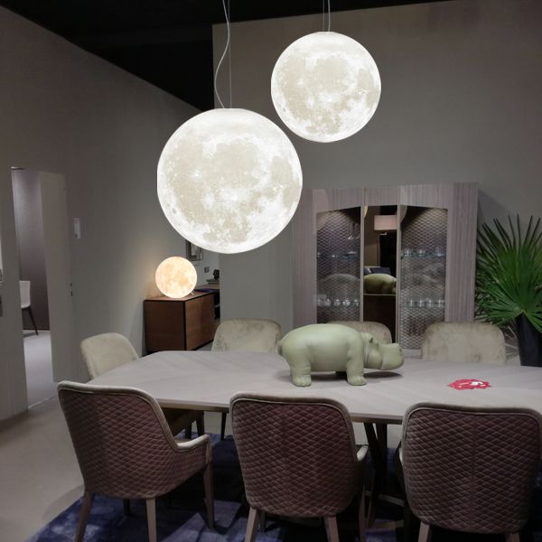 Dining room with large moon-shaped pendant lights hanging above a table.