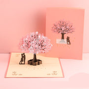 Pop-up card with cherry blossom tree and couple design on a pink background