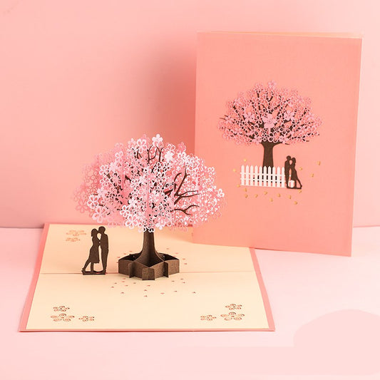 Pop-up card with cherry blossom tree and couple design on a pink background