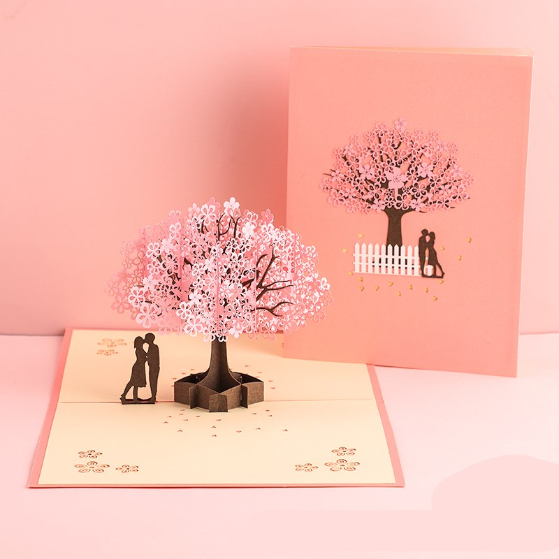 Pop-up card with cherry blossom tree and couple design on a pink background