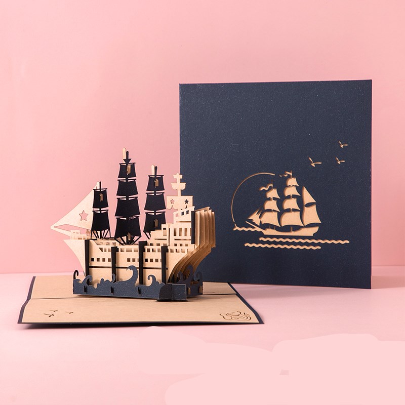 Pop-up ship card with a navy blue cover featuring a ship illustration on a pink background