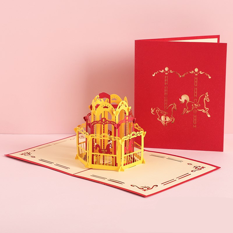 Red 3D pop-up card with a yellow birdcage design on a pink background