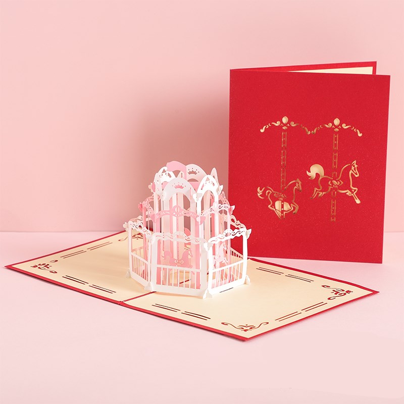 Red 3D pop-up card with a white carousel design on a pink background