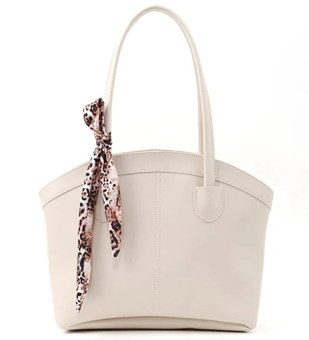 Beige tote bag with a leopard print scarf draped over it on a white background