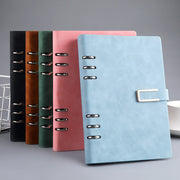 Set of five notebooks in different colors with a metal clip on a gray background