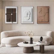Modern living room with a beige sofa, abstract art, and decorative items.