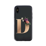 Phone case with a gold letter 'D' and floral design on a black background