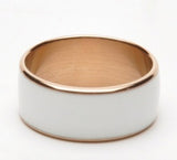 Ring with gold band and white ceramic core on a white background
