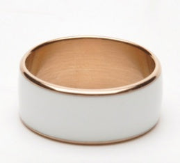 Ring with gold band and white ceramic core on a white background