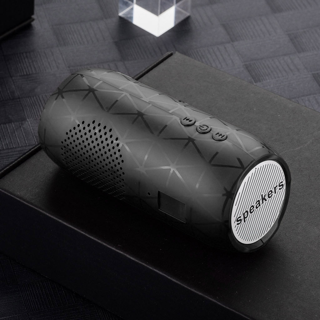 Black portable speaker with geometric design on a dark surface
