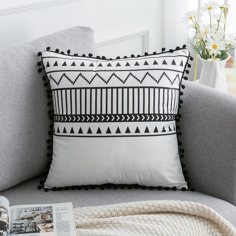 Decorative pillow with black and white pattern on a gray sofa