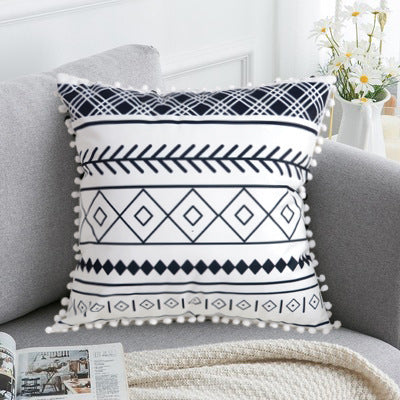 Decorative pillow with geometric pattern on a gray sofa