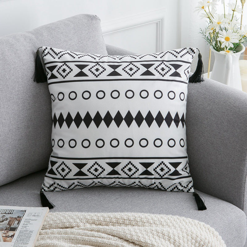Decorative pillow with black and white pattern on a gray sofa