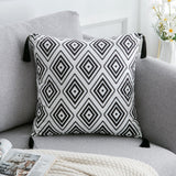 Decorative pillow with black geometric pattern on a gray sofa