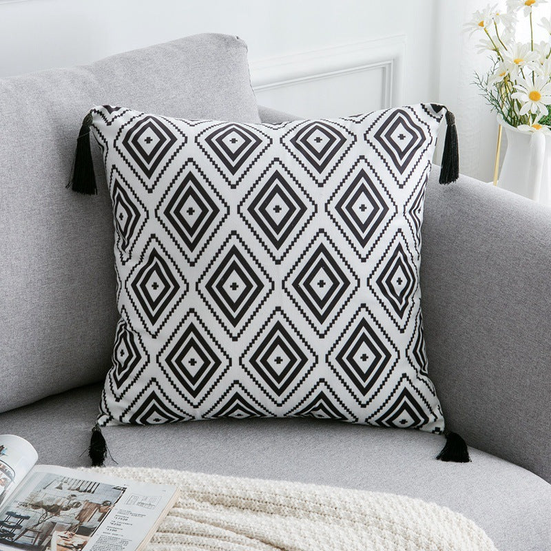 Decorative pillow with black geometric pattern on a gray sofa