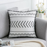 Decorative pillow with black patterns on a gray sofa