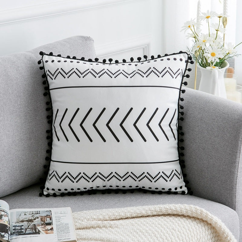 Decorative pillow with black patterns on a gray sofa