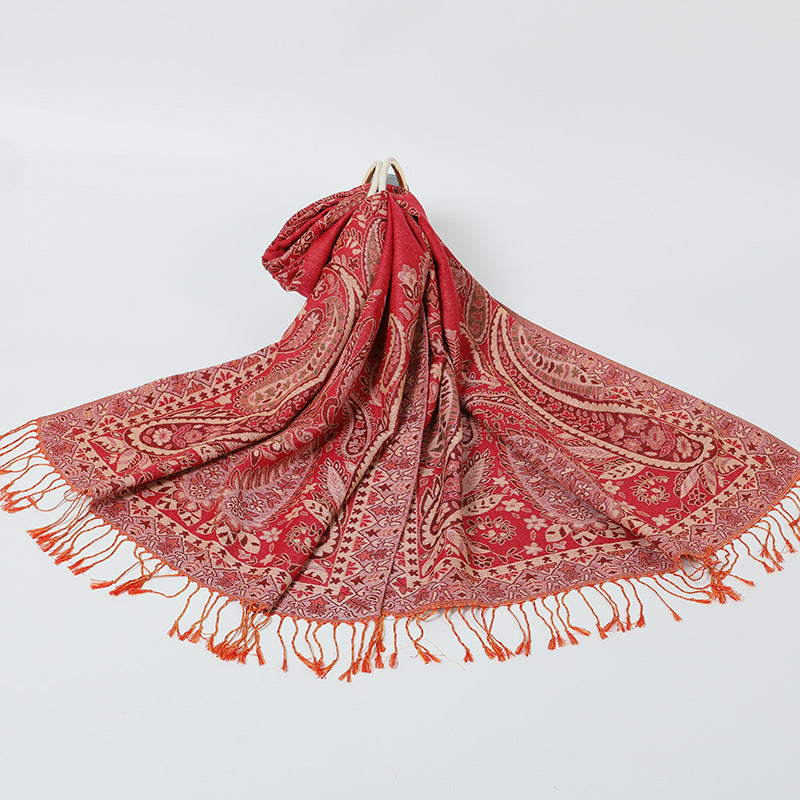 Red patterned scarf with fringes on a light gray background