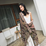 Woman wearing a patterned outfit standing on a balcony.