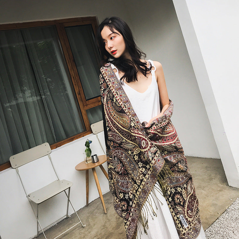 Woman wearing a patterned outfit standing on a balcony.