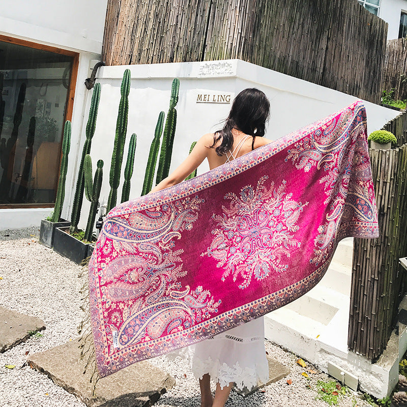 Woman holding a pink and white patterned scarf outdoors with cacti in the background