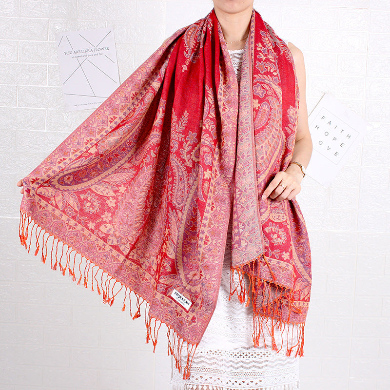 Person wearing a red paisley scarf on a white background