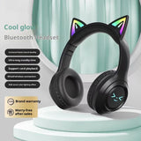 Black Bluetooth headphones with cat ears on a white stand, featuring RGB lighting effects.