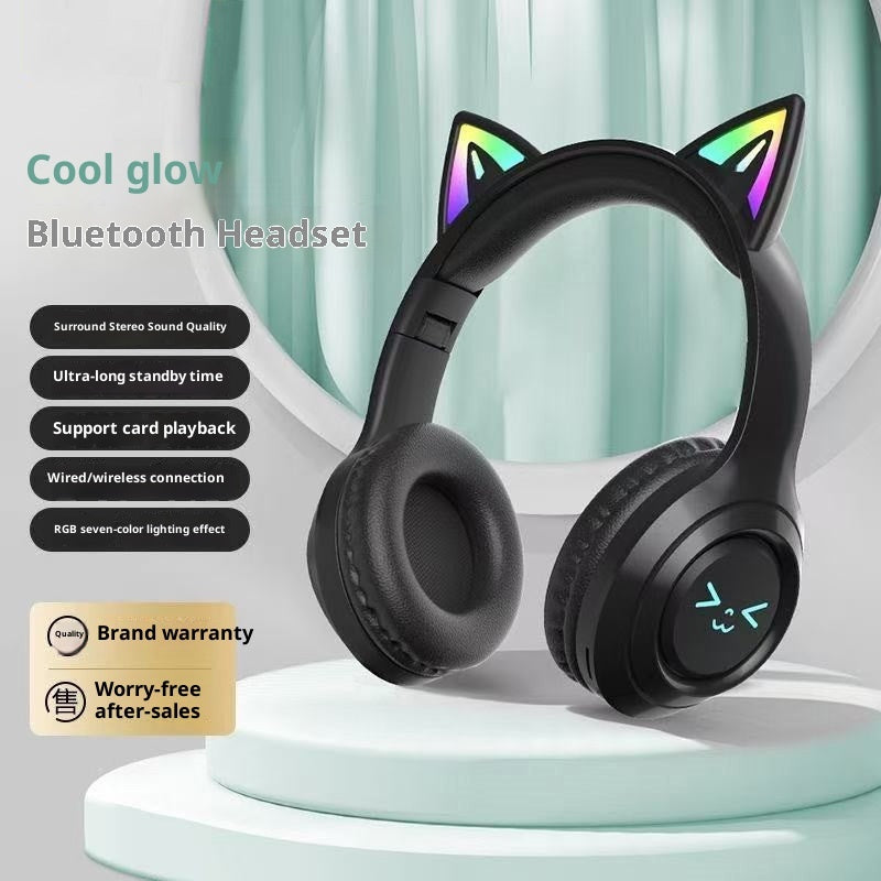 Black Bluetooth headphones with cat ears on a white stand, featuring RGB lighting effects.