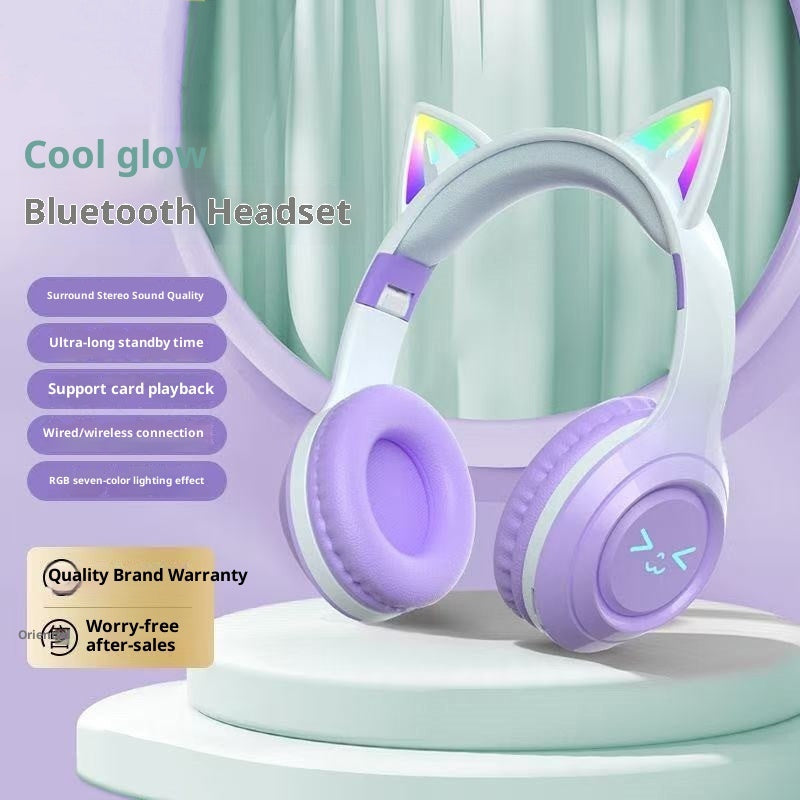 Purple Bluetooth headset with cat ears on a stand against a light green curtain background