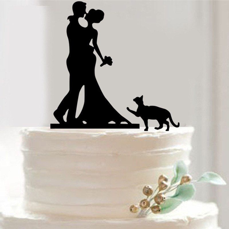Silhouette of a couple with a dog on a wedding cake against a white background