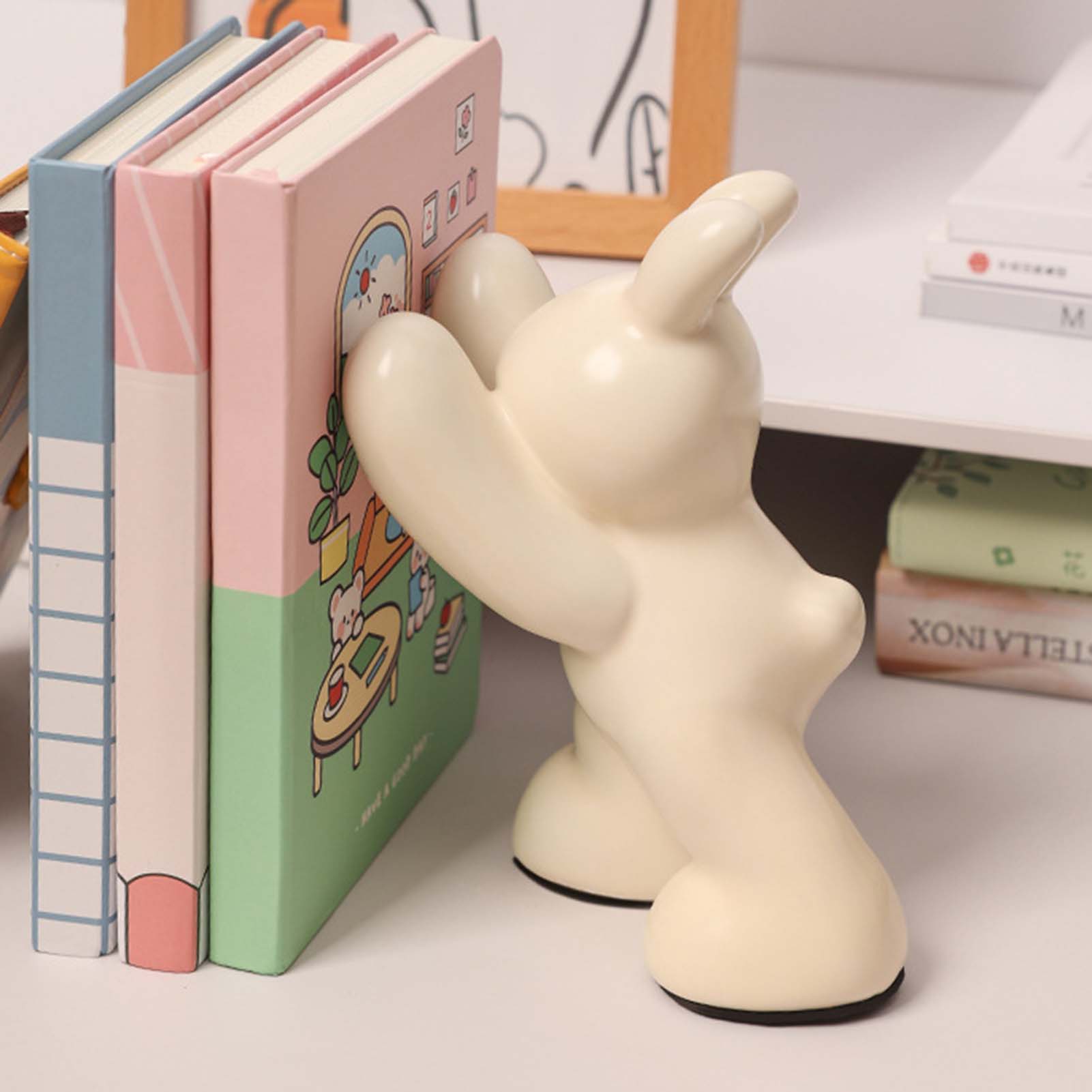 Creative ceramic animal figurine bookends holding a row of books and magazines on a shelf