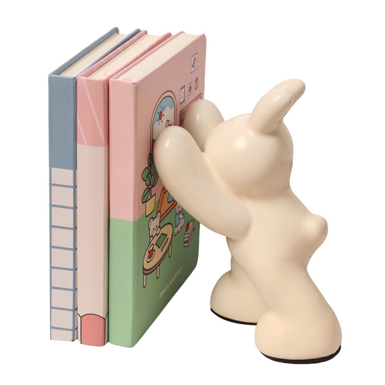 Unicorn-shaped bookend holding three books on a white background