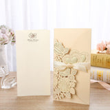 Decorative card with floral design and ribbon on a wooden surface.