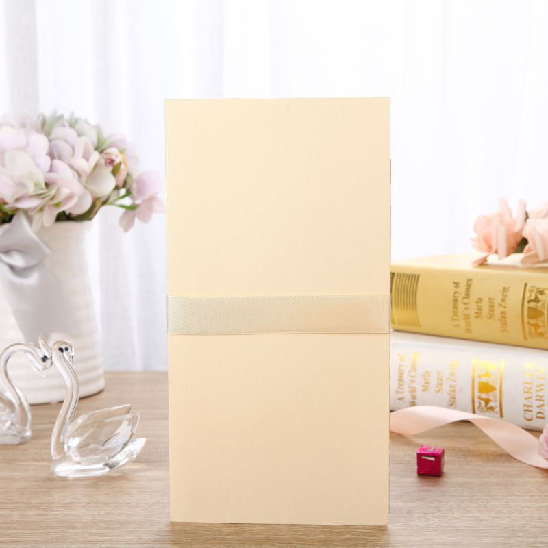 Beige box on a wooden surface with decorative items including a vase, books, and swan figurines.