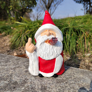 Gnome figurine with a red hat and white beard sitting on a stone surface with greenery in the background.