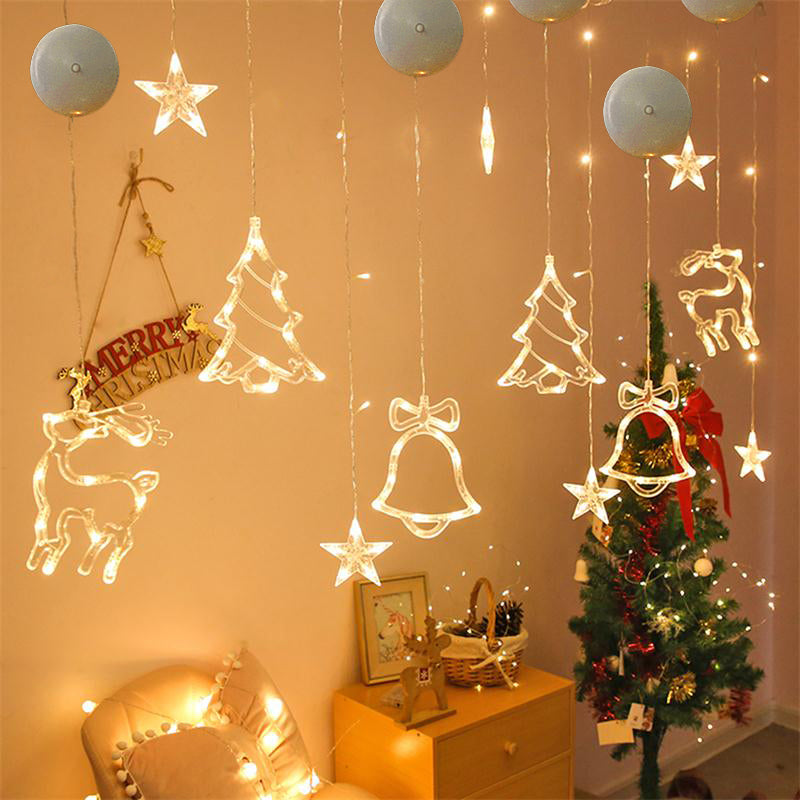 Decorative string lights with Christmas-themed decorations on a wall.