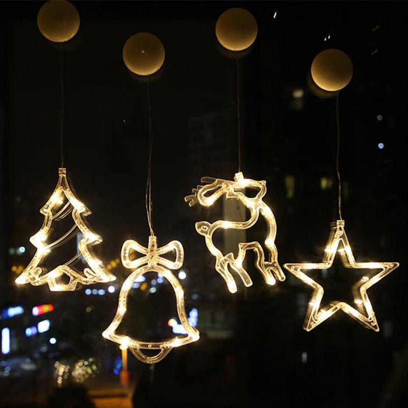 Decorative LED lights shaped like a tree, bell, reindeer, and star against a night sky.