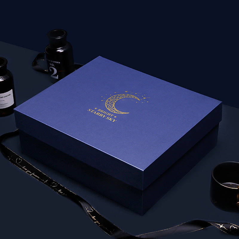 Blue gift box with 'Starry Sky' logo on a dark surface with decorative items.