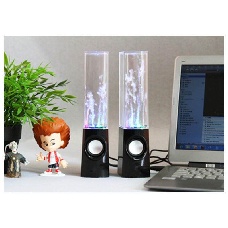 Two colorful water lamps on a desk with a laptop and small figurine.