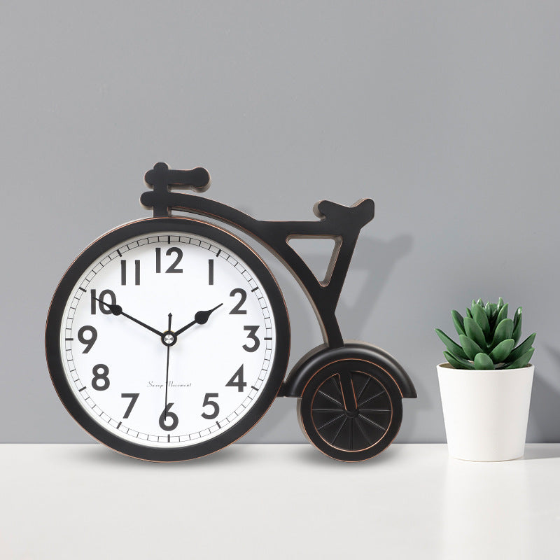 Decorative clock shaped like a bicycle with a potted plant on a gray background