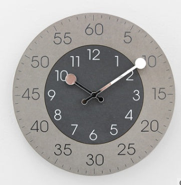 Round wall clock with gray casing and black face on a white background