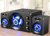 Black speaker system with blue LED lights on a wooden surface.