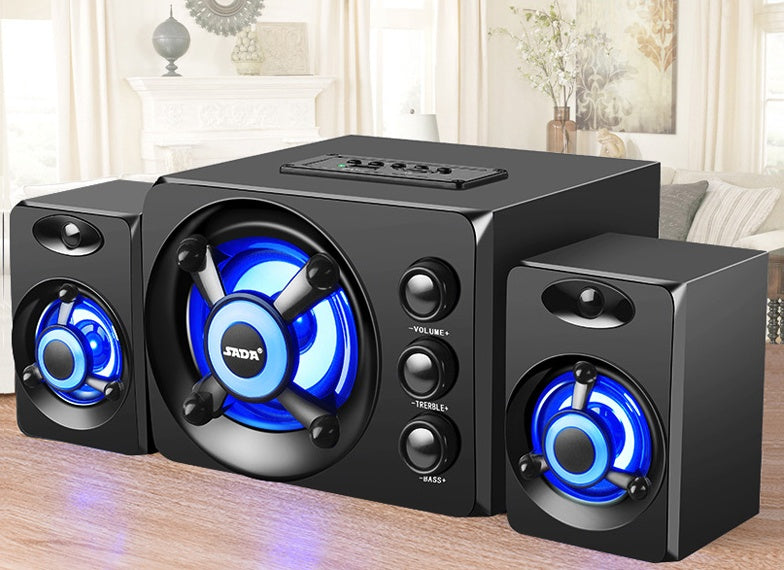 Black speaker system with blue LED lights on a wooden surface.