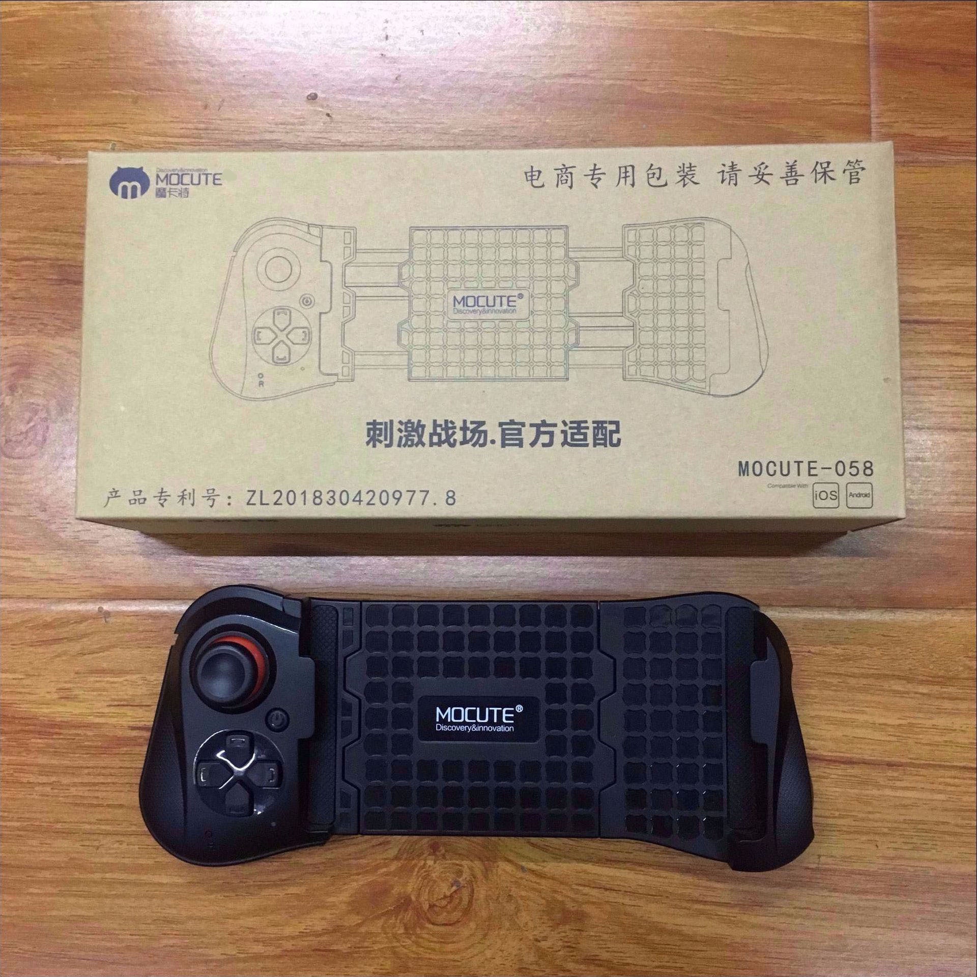 Black gaming controller with MOCUTE branding on a wooden surface, next to its packaging box.