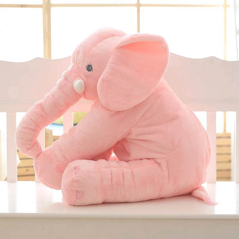 Pink elephant plush toy on a white surface with a blurred background