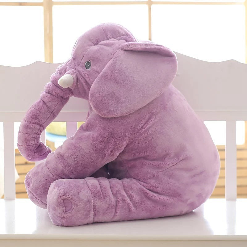 Purple plush elephant toy on a white surface with a blurred background