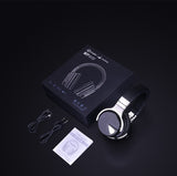 Headphones with packaging, cable, and manual on a dark background